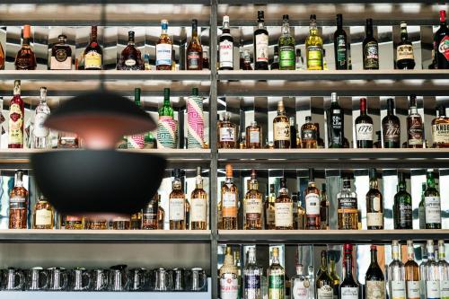 a shelf filled with lots of bottles of alcohol at FREIgeist Göttingen Innenstadt, A Member of Design Hotels in Göttingen