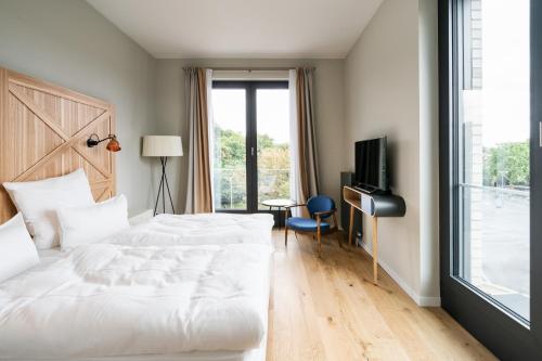 a hotel room with a bed and a television at FREIgeist Göttingen Innenstadt, A Member of Design Hotels in Göttingen