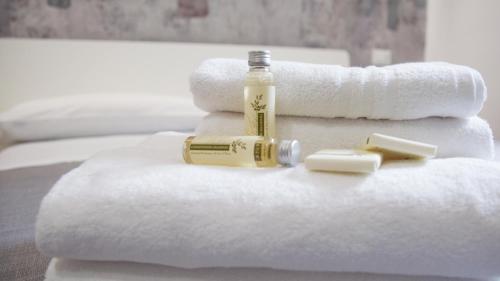 a pile of towels with a bottle of soap and a bottle at Suite Inn Rome in Rome
