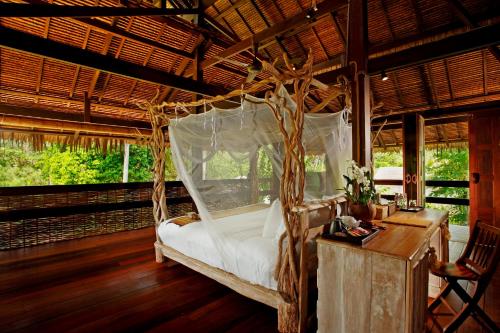 a bedroom with a bed in a room with windows at Koyao Island Resort in Ko Yao Noi