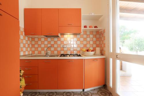 a kitchen with orange cabinets and a sink at Villa Mele in Lido Marini