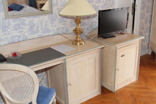 a desk with a television and a lamp on it at Hotel Royal Albion in Mesnil-Val-Plage