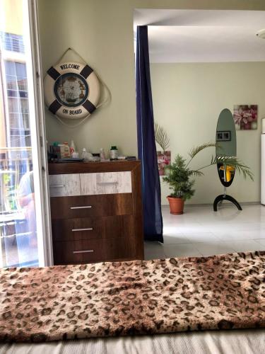 a room with a dresser and a clock on the wall at Alice Apartment in Obzor