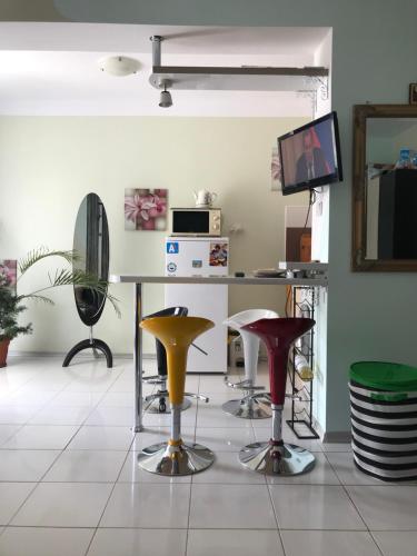 a room with chairs and a table and a television at Alice Apartment in Obzor