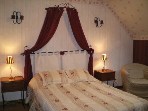 1 dormitorio con 1 cama, 1 silla y 2 lámparas en le tilleul, en Caumont