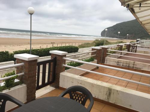 balcón con mesa y sillas y playa en Apartamento Edificio la playa, en Santoña