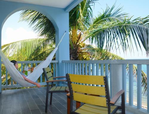 a man in a hammock on a porch overlooking the ocean at Parrot Cove Lodge in Hopkins