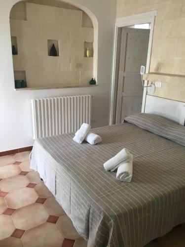 a bedroom with a bed with two towels on it at La dimora di nonna Giuliana in Ostuni