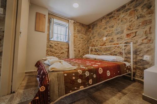 a bedroom with a bed and a stone wall at Eleutheria in Kalamata