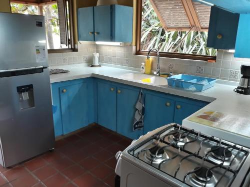 cocina con armarios azules y fogones en Seascape Beach House Surferspoint Barbados, en Christ Church