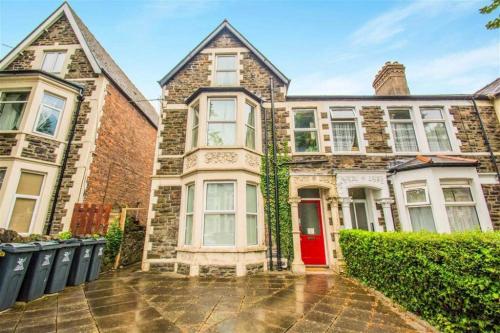 a large brick house with a red door at Richmond Road Guest House in Cardiff