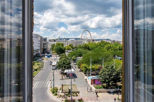 a view from a window of a city with a ferris wheel at Luxury & Panorama Apartments in Budapest