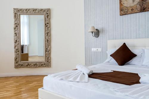 a bedroom with a white bed and a mirror at Luxury & Panorama Apartments in Budapest