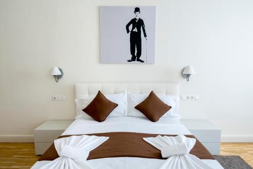 a bedroom with a white bed with a man on the wall at Luxury & Panorama Apartments in Budapest