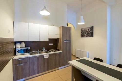 布達佩斯的住宿－豪華全景公寓式酒店，厨房配有白色橱柜、水槽和柜台。