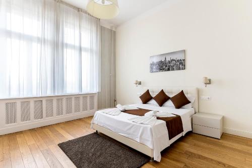 a white bedroom with a large bed and a window at Luxury & Panorama Apartments in Budapest