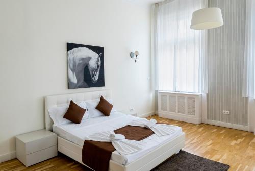a white bedroom with a bed in a room at Luxury & Panorama Apartments in Budapest
