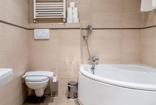 a bathroom with a toilet and a tub and a sink at Luxury & Panorama Apartments in Budapest