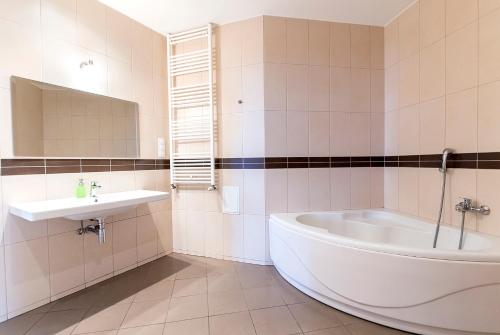 a white bathroom with a tub and a sink at Luxury & Panorama Apartments in Budapest