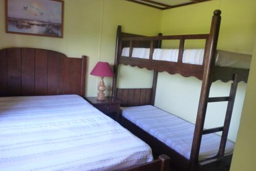 a bedroom with two bunk beds and a lamp at Relais Du Saussay in Pertheville-Ners