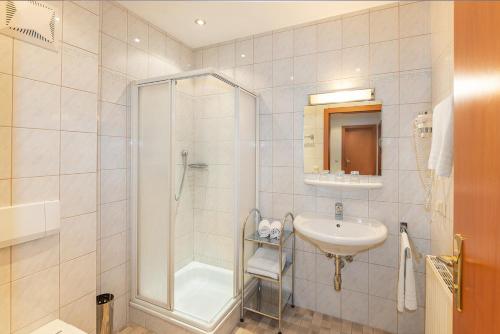 a bathroom with a shower and a sink at Dr. Aufmesser Appartements in Obertauern