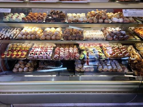 a display case in a bakery filled with lots of donuts at Casa Marianna in Alcamo