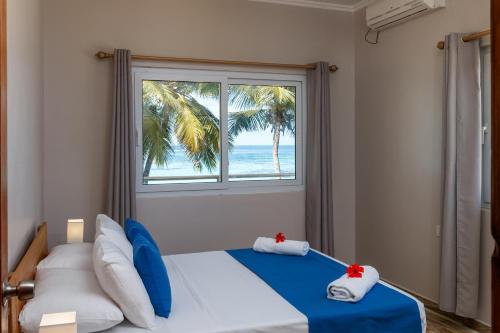 a bedroom with a bed with a view of the ocean at Shanaz Beachside Retreat in Anse Royale