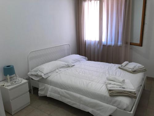 a white bed in a bedroom with a window at Case sul mare in Palau