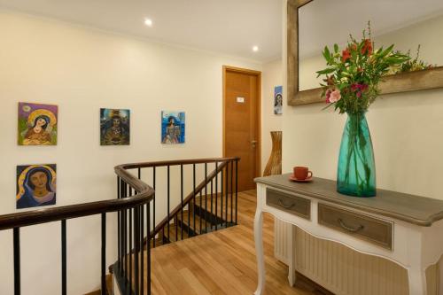 a hallway with a staircase and a vase of flowers on a table at Casa Bellavista Hotel in Santiago