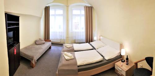 een slaapkamer met een bed, een bank en een raam bij Hotel U dvou zlatých klíčů in Praag