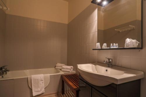 a bathroom with a sink and a bath tub and a sink at Résidence du Château de Bégué in Cazaubon