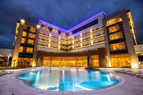 a hotel with a large swimming pool at night at TRYP by Wyndham Izmit in Kocaeli