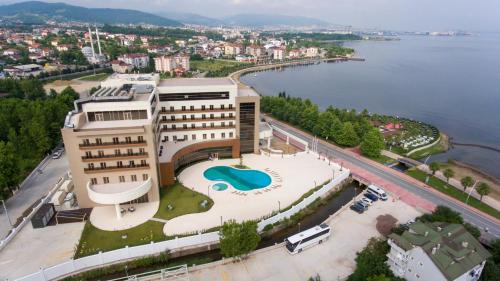 a building with a swimming pool in front of the water at TRYP by Wyndham Izmit in Kocaeli