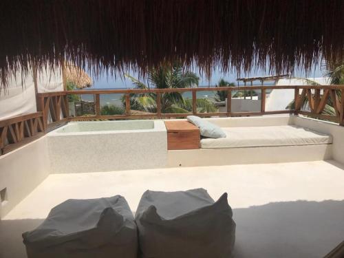 
a room with a white couch and a white tub at Azucar Hotel Tulum in Tulum
