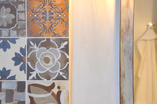 a bathroom with a shower curtain and a tile wall at Chaido Studios in Plaka Milou