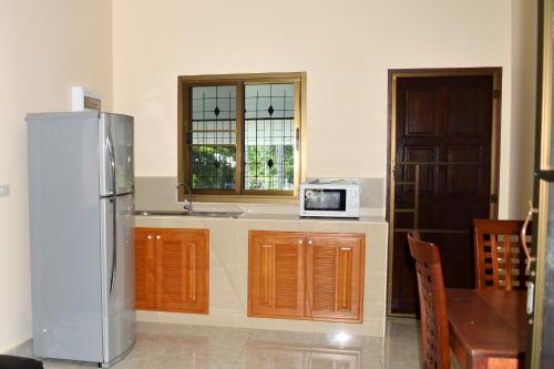 a kitchen with a refrigerator and a sink and a window at Kate House Bangsaphan in Bang Saphan
