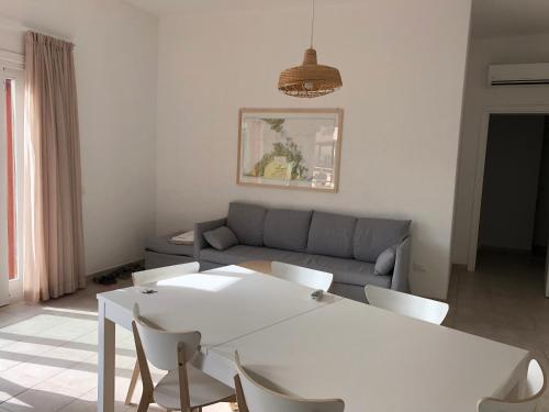 a living room with a white table and chairs at Case sul mare in Palau