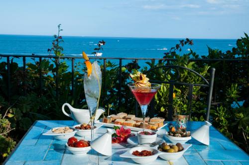 un tavolo con un vassoio di cibo e una bevanda di Hotel Palladio a Giardini Naxos