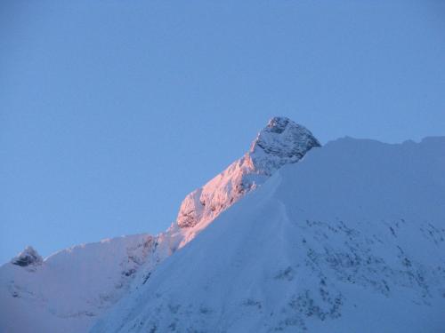 a snow covered mountain with the sun shining on it at Ferienparadies Spielmannsau in Oberstdorf