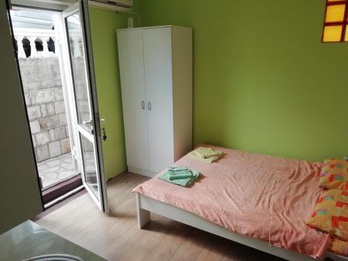 a bedroom with green walls and a bed and a mirror at Petrovic house in Herceg-Novi