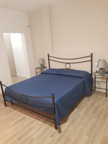 a bedroom with a bed with a blue comforter at Il Giardino degli Ulivi in Rapolano Terme