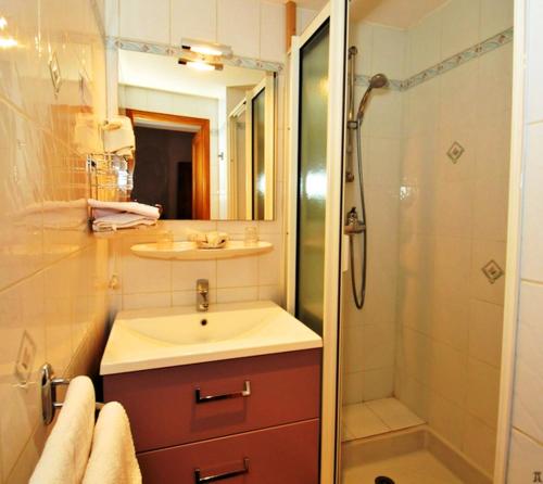a bathroom with a sink and a shower at Hôtel La Montagne Fleurie in Barèges