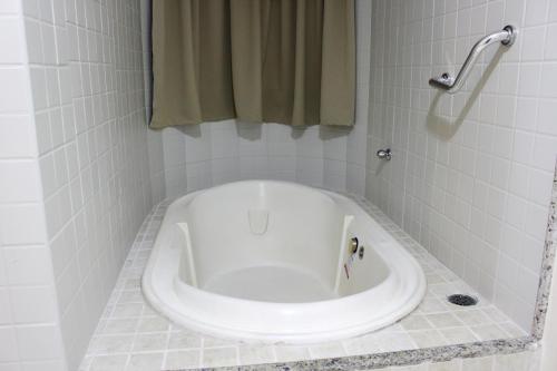 a bath tub in a bathroom with a shower at Hot Springs Hotel - Via Conchal in Caldas Novas