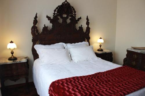 a bedroom with a large bed with a red blanket at Graciosa Guest House in Ponte de Lima