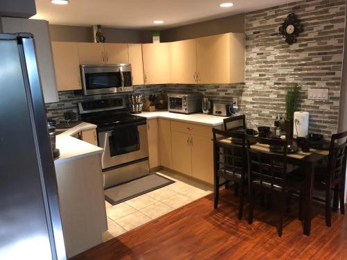 a kitchen with a stove and a table with chairs at Cozy and modern 3 bedroom in central location! in Victoria
