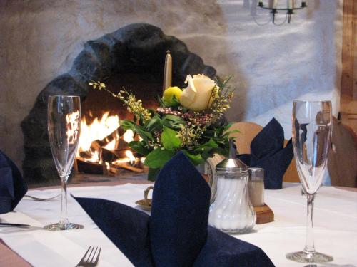a table with wine glasses and a fireplace at Ferienparadies Spielmannsau in Oberstdorf