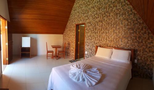 1 dormitorio con cama y pared de ladrillo en Pousada carvalho, en Conselheiro Lafaiete
