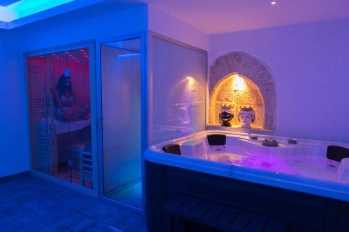 a bathroom with a large tub with purple lighting at Vento di Sicilia in Siracusa