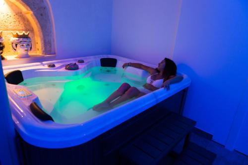 a woman sitting in a hot tub in a room at Vento di Sicilia in Siracusa