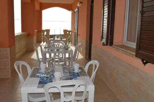 a dining room with white tables and white chairs at Carrubella Santa Zita in Licata